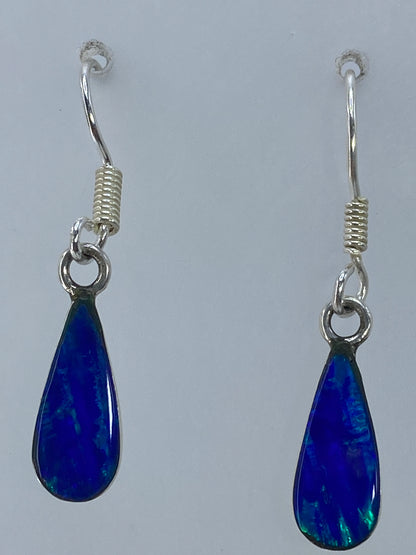 Aretes puestos en la oreja, largos y elegantes, color verde olivo