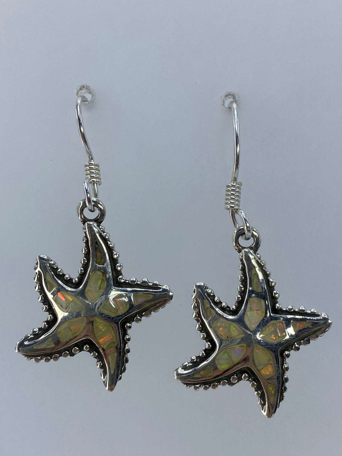 Detalle de la incrustación a mano del ópalo de fuego en la estrella marina de plata