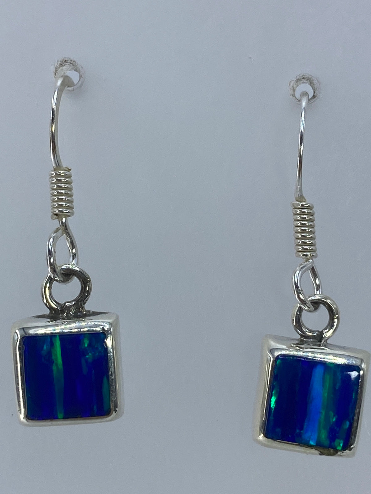 Aretes colgando mostrando el largo de 2.7 cm y el engaste a mano