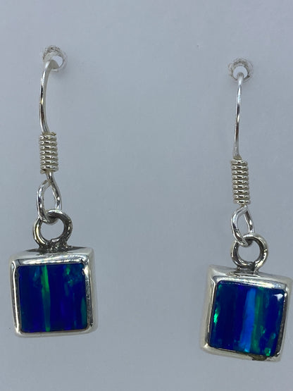 Aretes colgando mostrando el largo de 2.7 cm y el engaste a mano