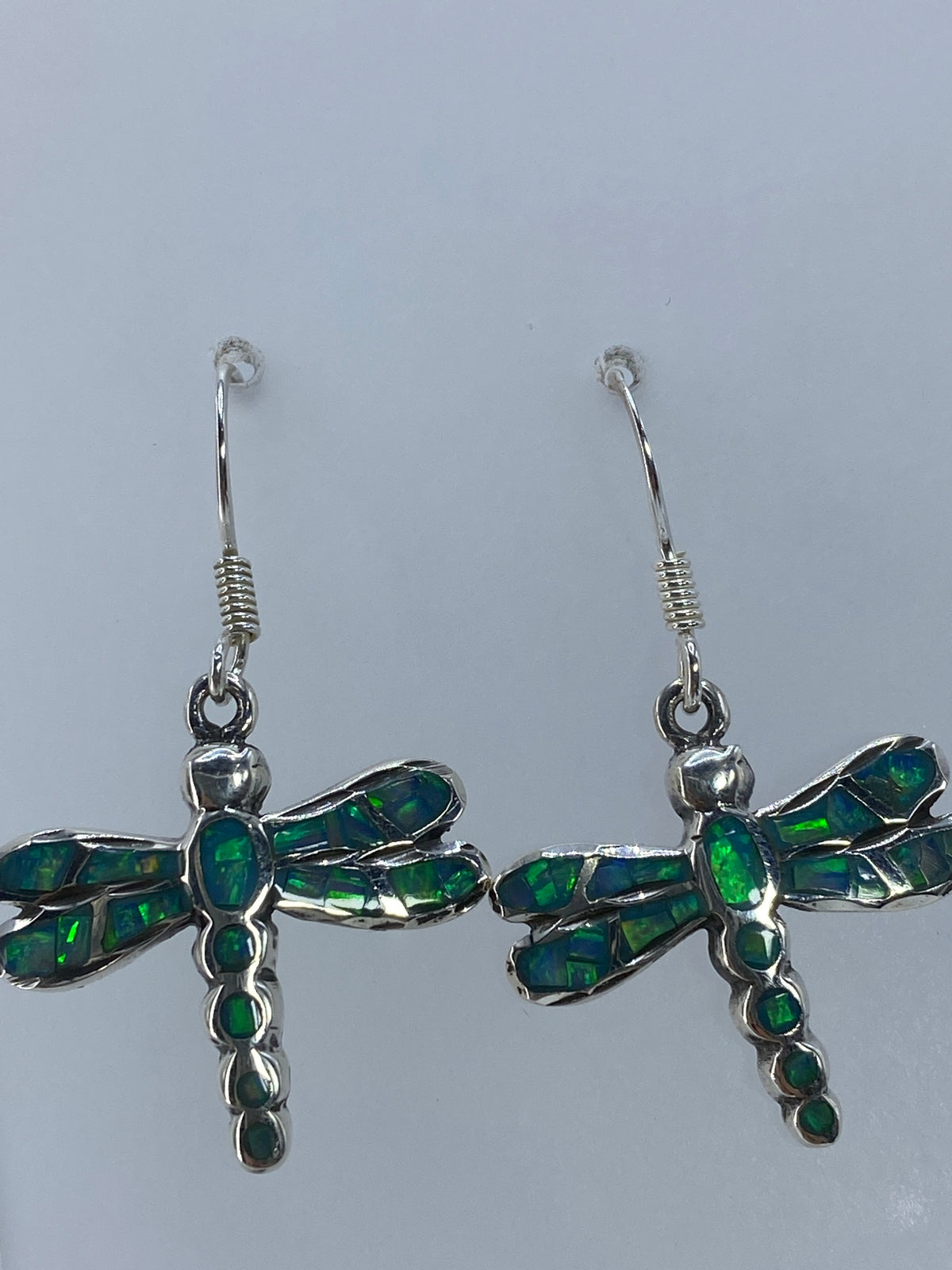 Aretes de libélula sobre regla milimétrica mostrando 3.5 cm de largo total del par
