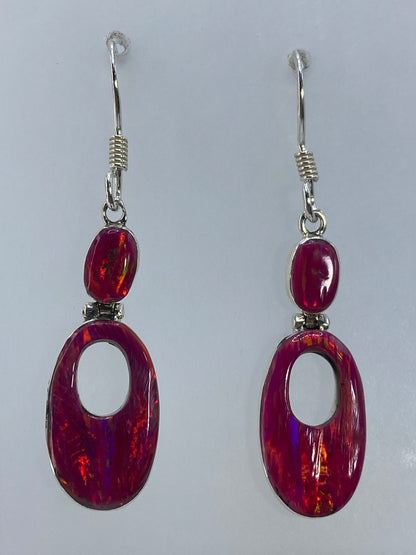 Detalle de cada arete mostrando los destellos rojos y naranjas del ópalo de fuego