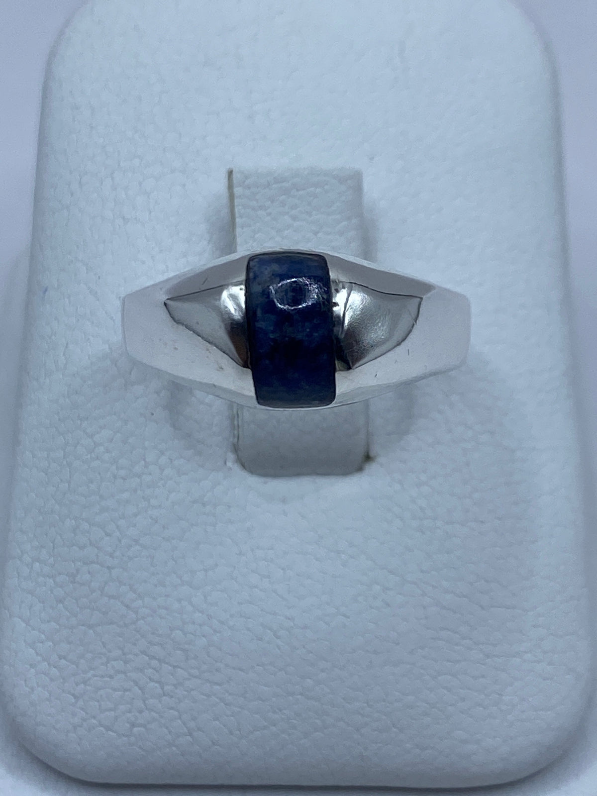 Anillo de plata con lapislázuli azul engastado, vista frontal sobre fondo blanco