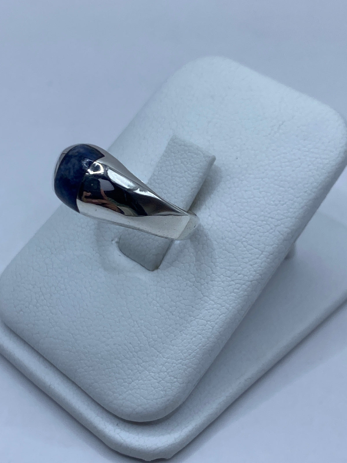 Anillo de plata y lapislázuli azul en la mano de una persona, mostrando el color profundo de la piedra