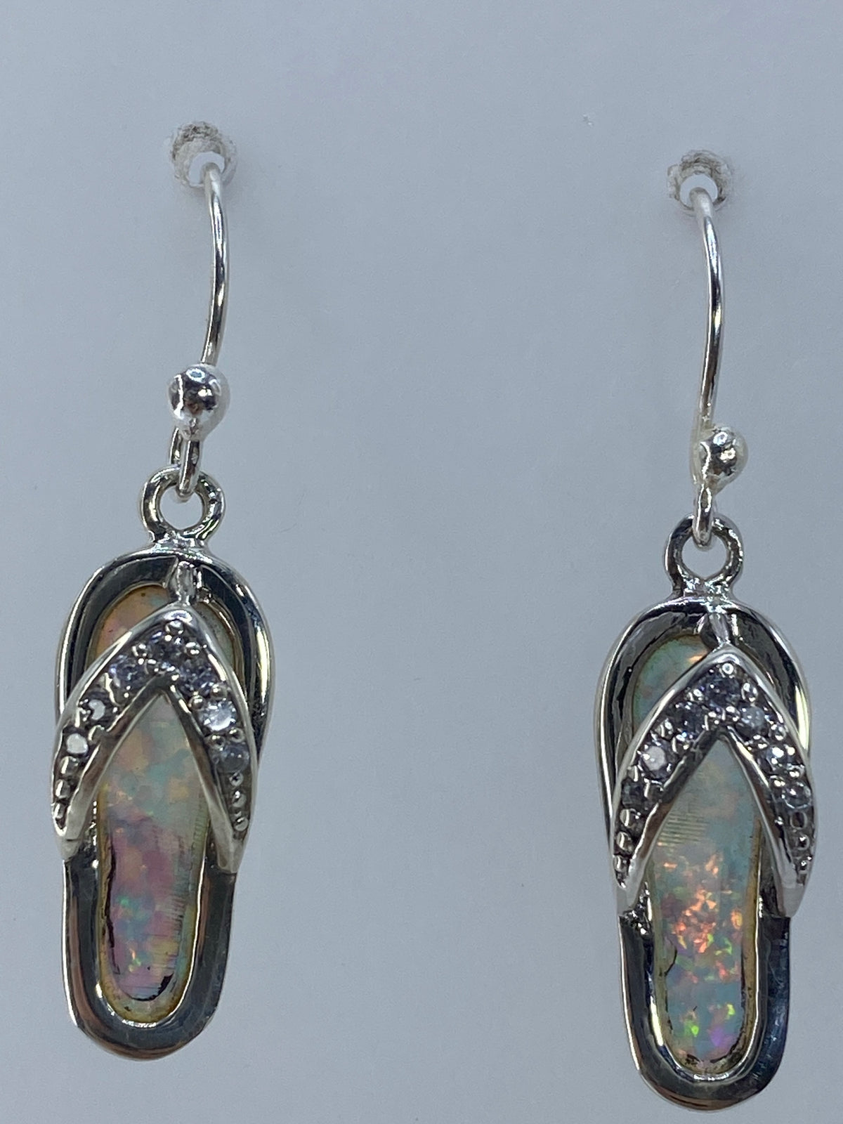 Aretes de ópalo multicolor sobre regla de medida mostrando 3.1 cm de largo
