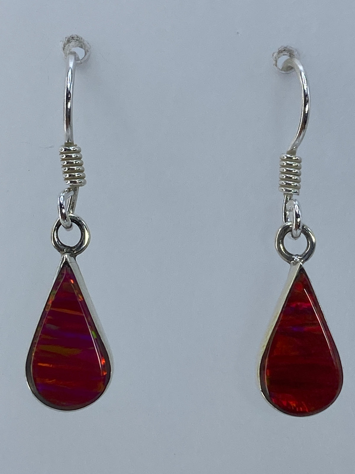 Aretes en la mano mostrando el color rosa intenso del ópalo