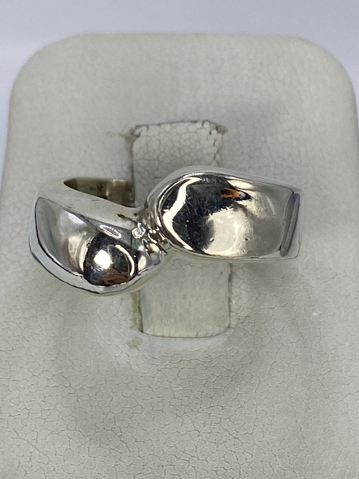 Anillo de plata cartoneado pulido en la mano de una mujer