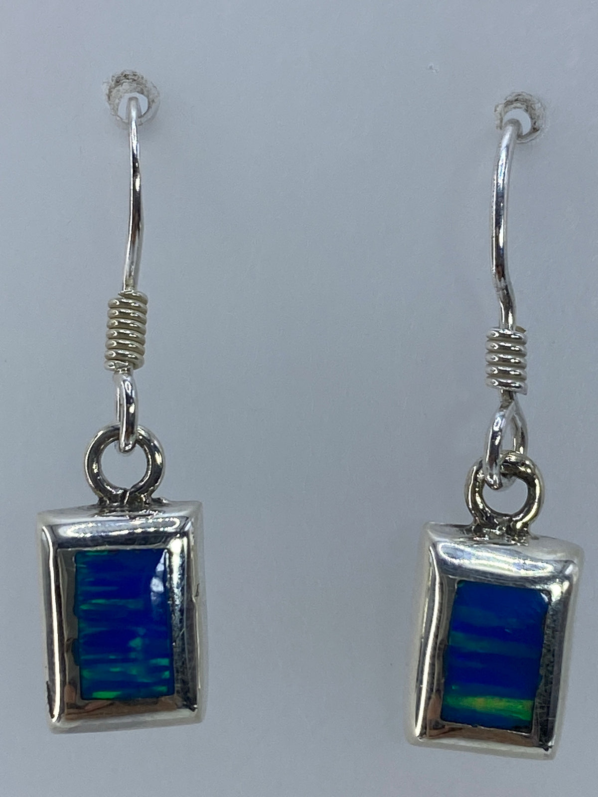 Aretes colgantes de ópalo de fuego mostrando el color verde natural de la piedra
