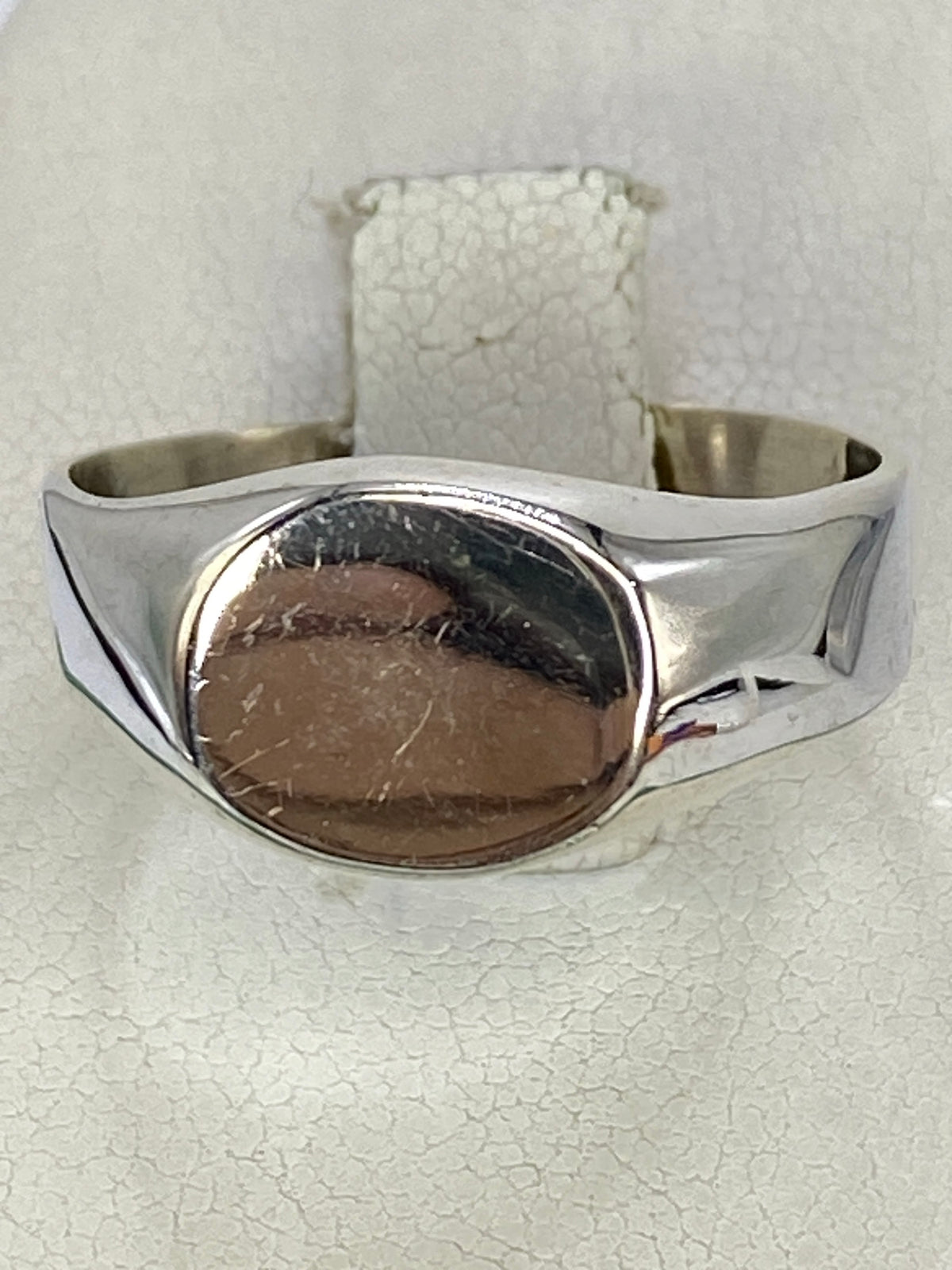 Detalle lateral del anillo plateado con acabado pulido brillante