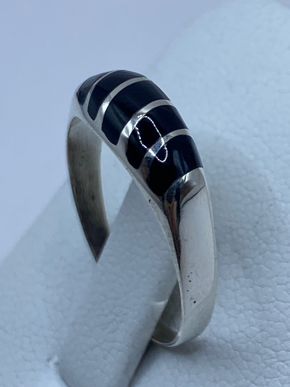 Detalle lateral del anillo mostrando el perfil de plata y ónix