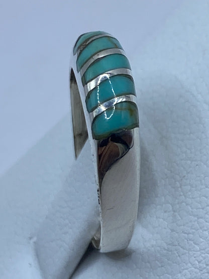 Anillo puesto en dedo, luciendo la turquesa azul cielo con bandas de plata