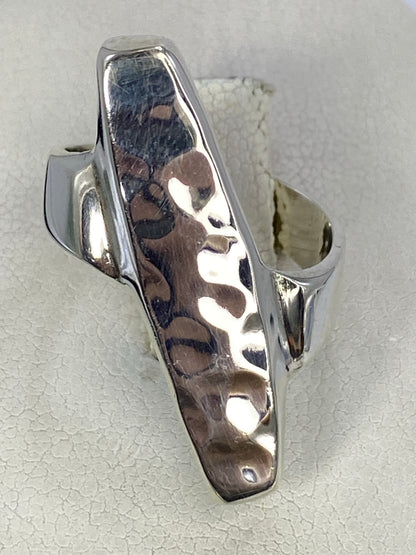 Anillo de plata repujado con diseño geométrico en relieve, visto de frente