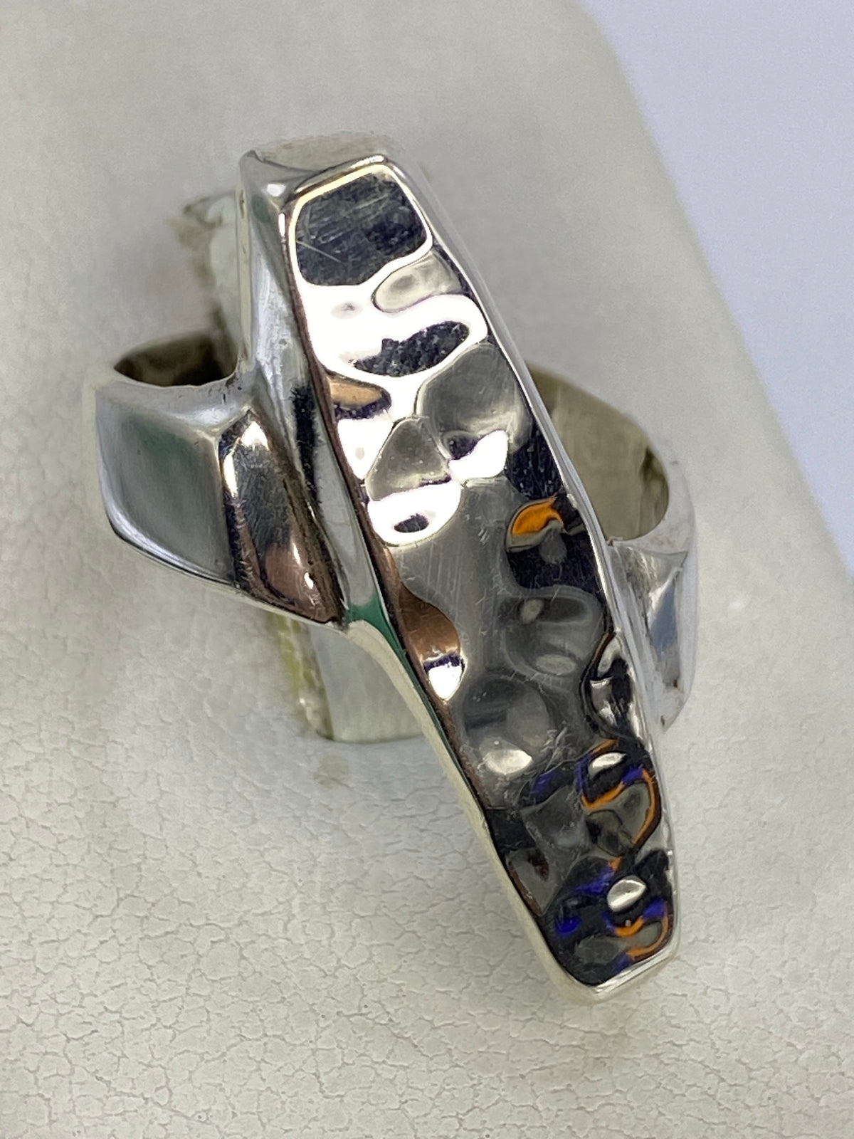 Detalle lateral del anillo de plata repujada mostrando la profundidad del trabajo artesanal