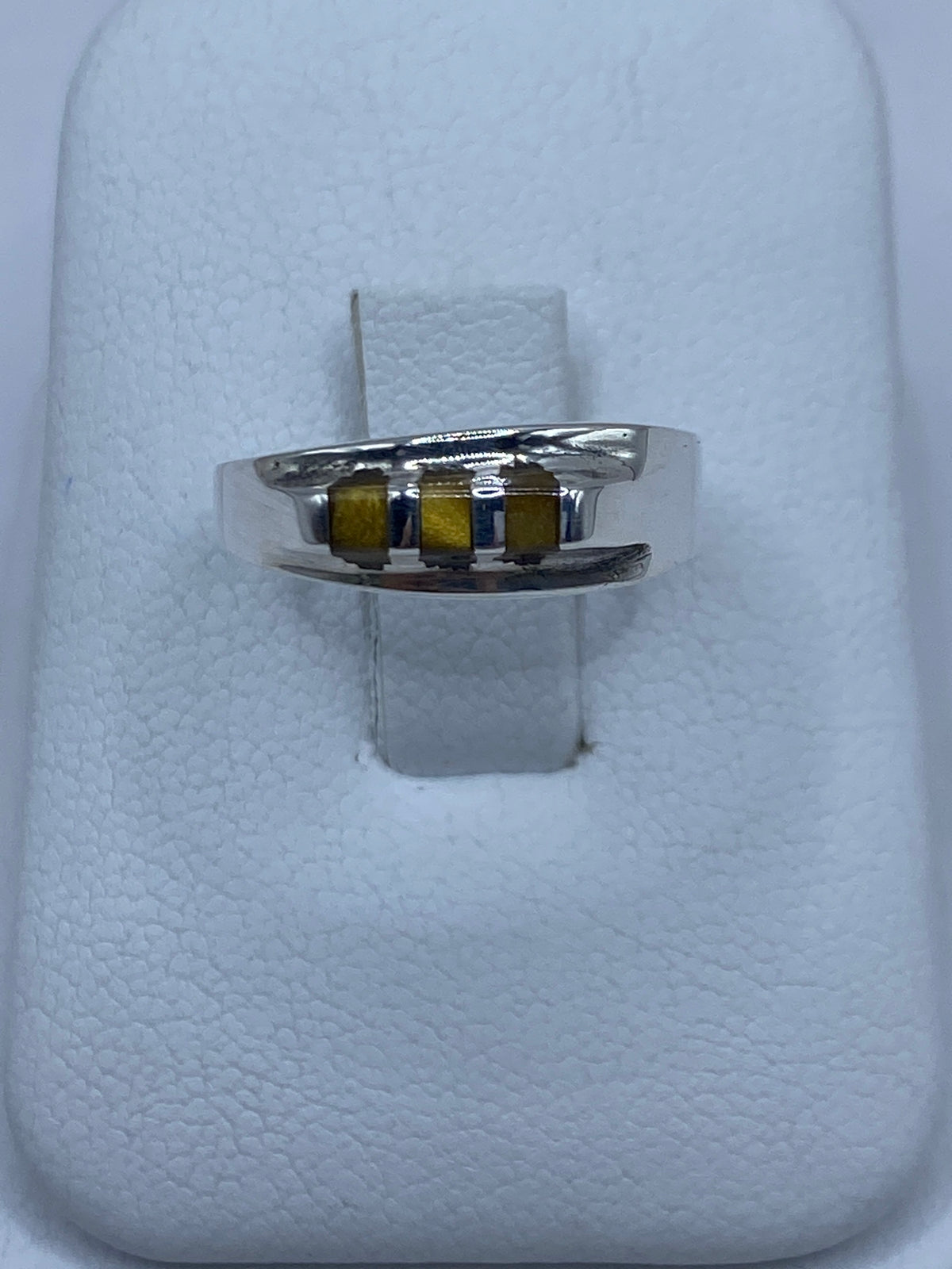 Anillo de plata con ojo de tigre café engastado en las manos