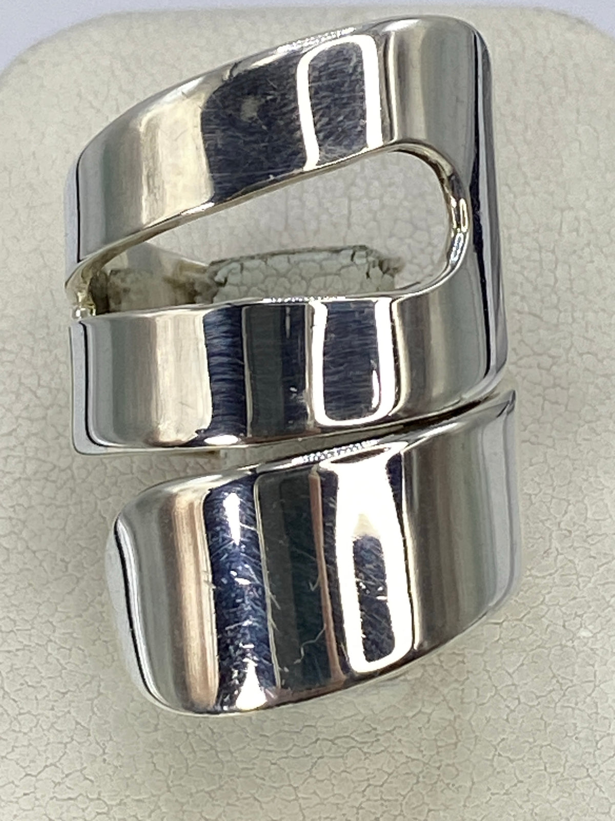 Anillo de plata calado visto de frente, mostrando el diseño cortado geométrico en brillo pulido