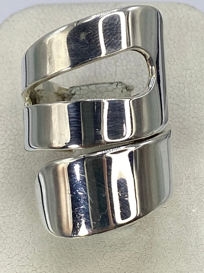Anillo de plata calado visto de frente, mostrando el diseño cortado geométrico en brillo pulido