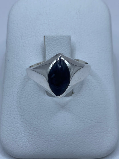 Anillo de plata 925 con piedra engastada a mano, vista frontal sobre almohadilla blanca