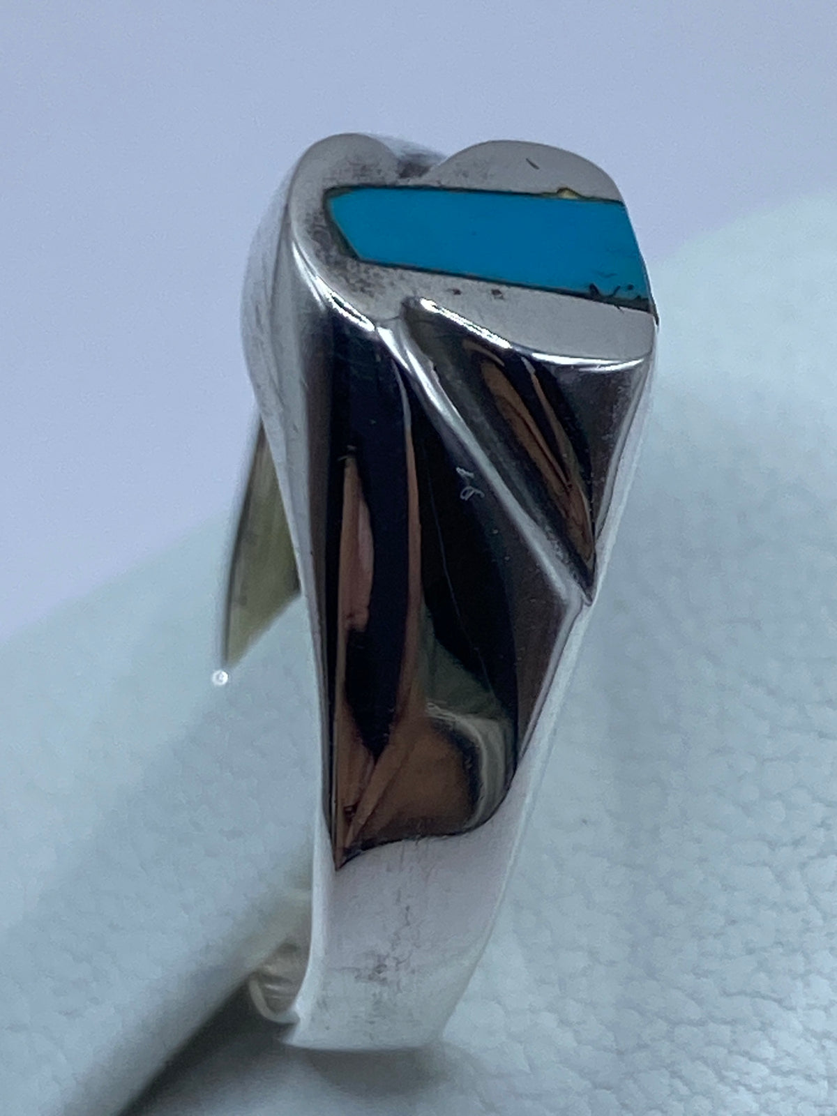 Anillo puesto en dedo, turquesa azul cielo brillando en plata pulida