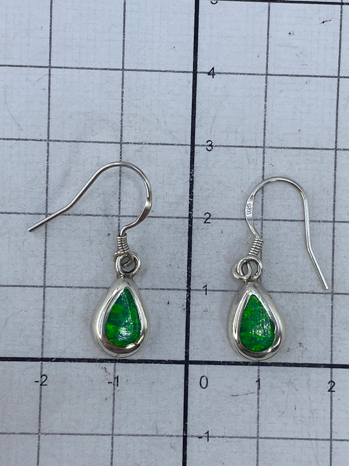 Aretes sobre escala de centímetros mostrando el tamaño de 2.7 cm