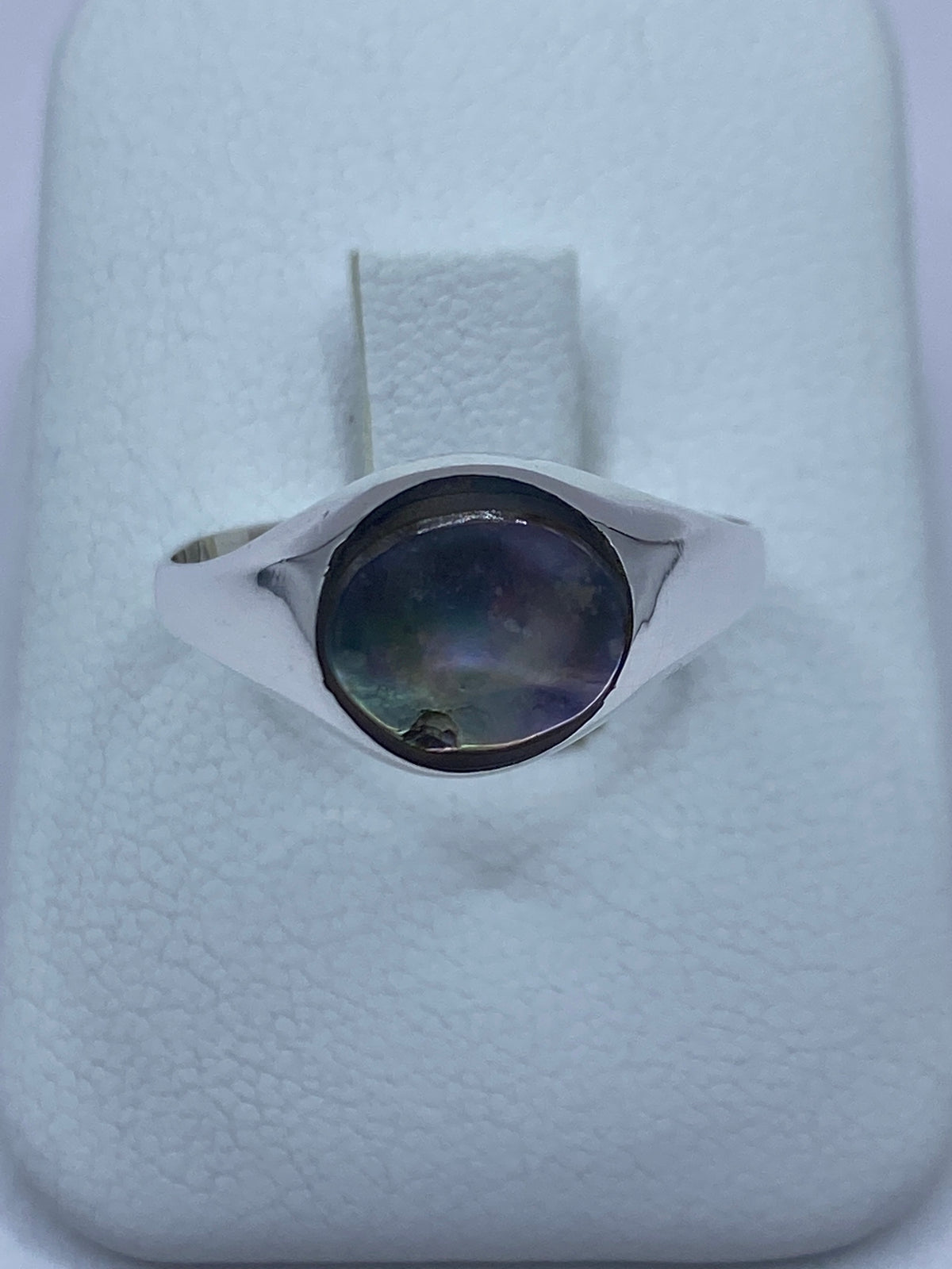 Anillo de plata 925 con concha de abulón iridiscente reflejando azules y verdes