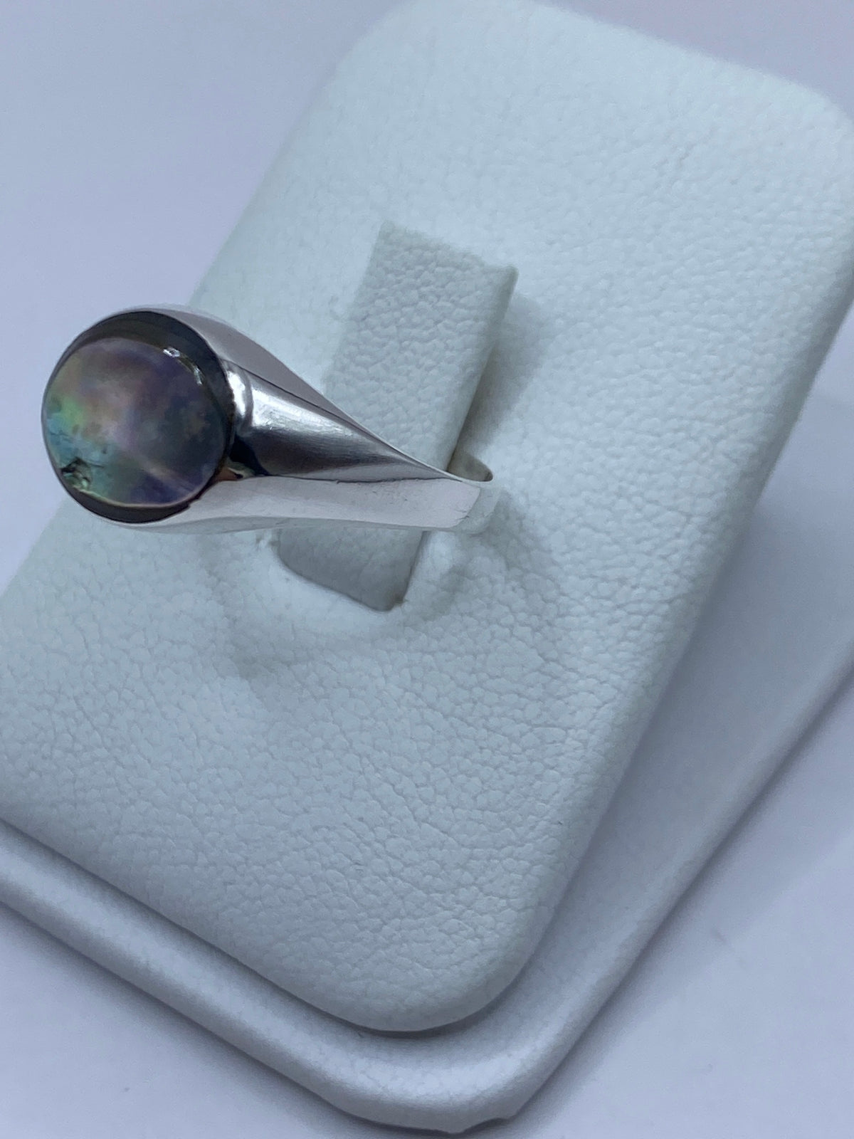 Vista lateral del anillo de plata con engaste a mano de concha de abulón