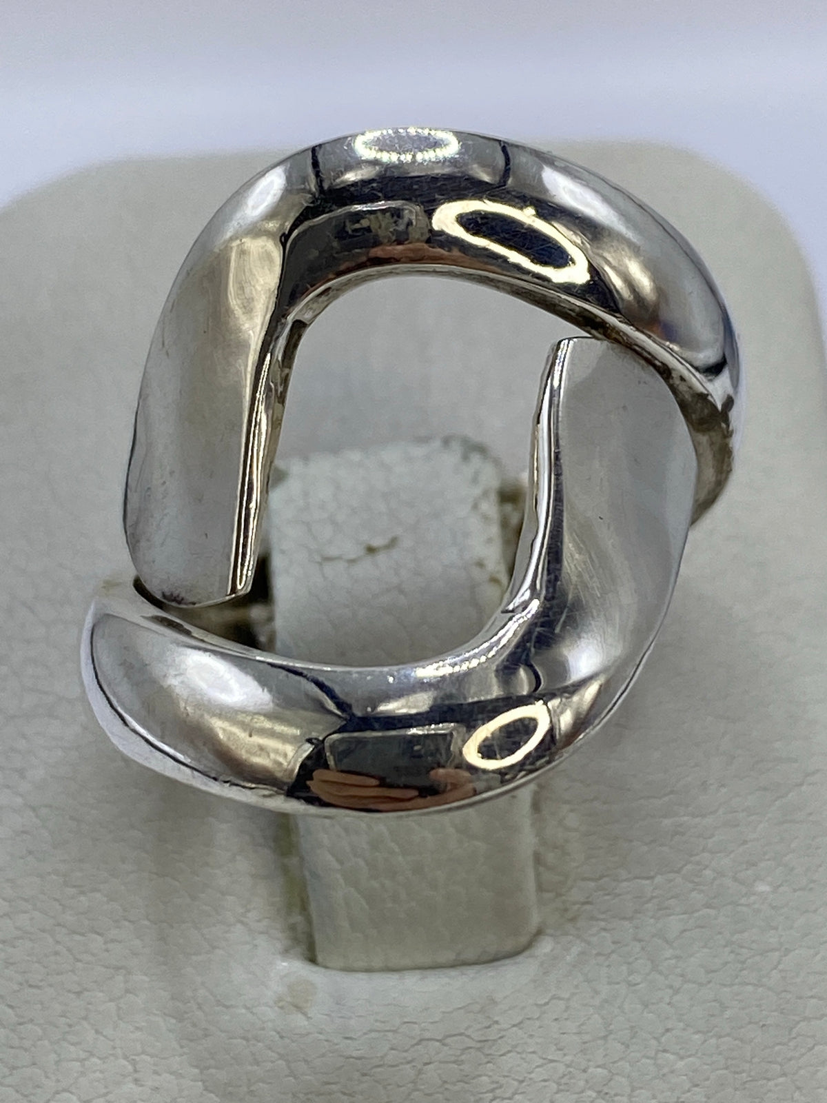 Anillo de plata calado geométrico en mano de mujer, mostrando los huecos perforados