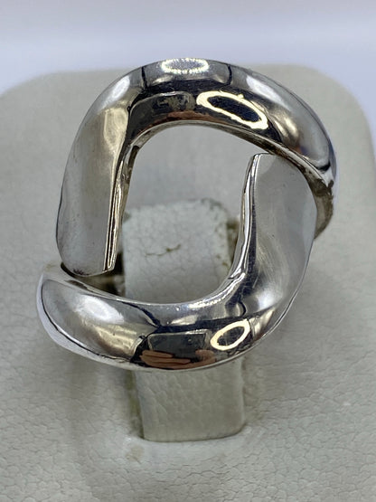 Anillo de plata calado geométrico en mano de mujer, mostrando los huecos perforados