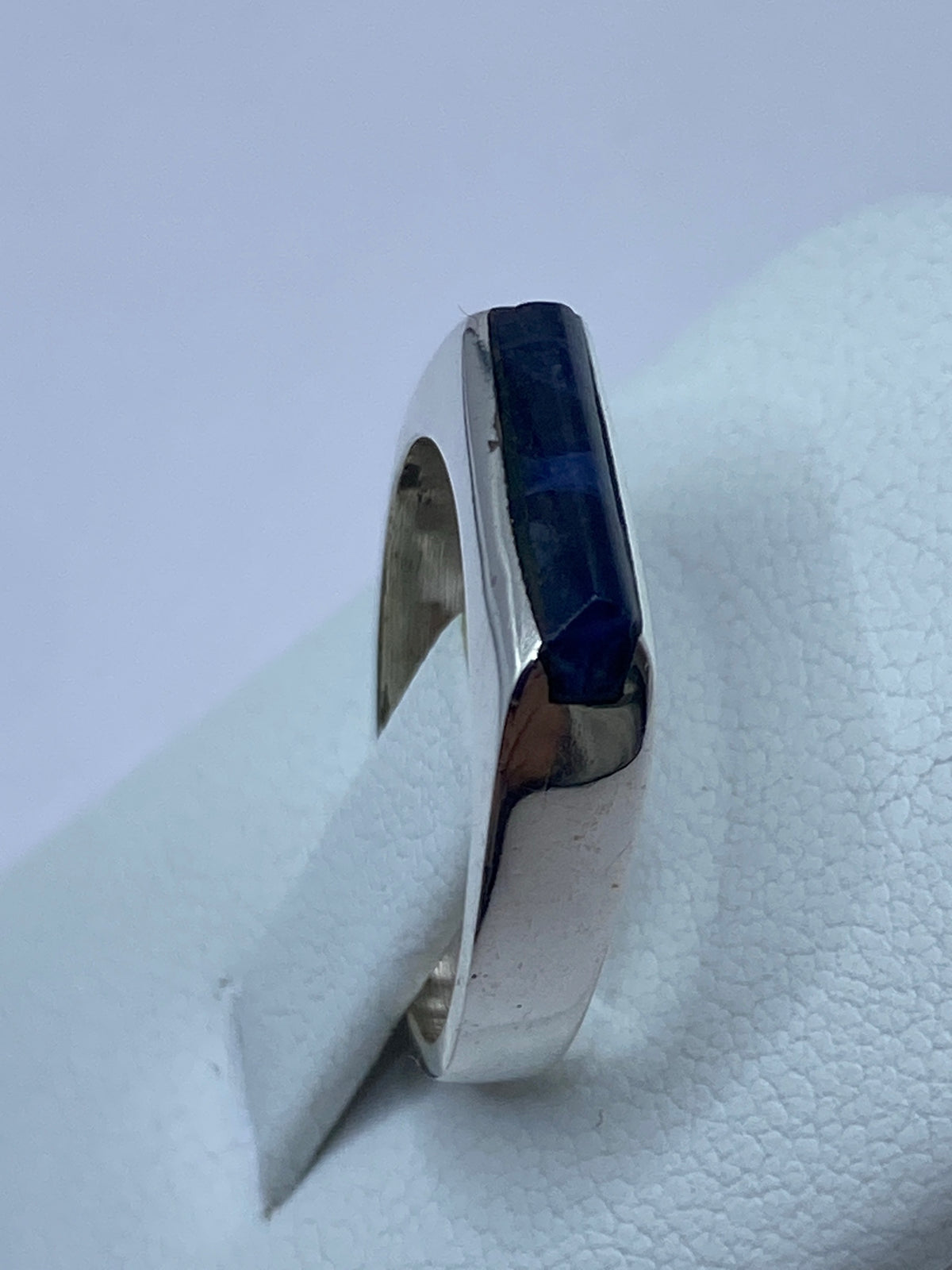 Anillo en la mano mostrando el color azul intenso de la piedra