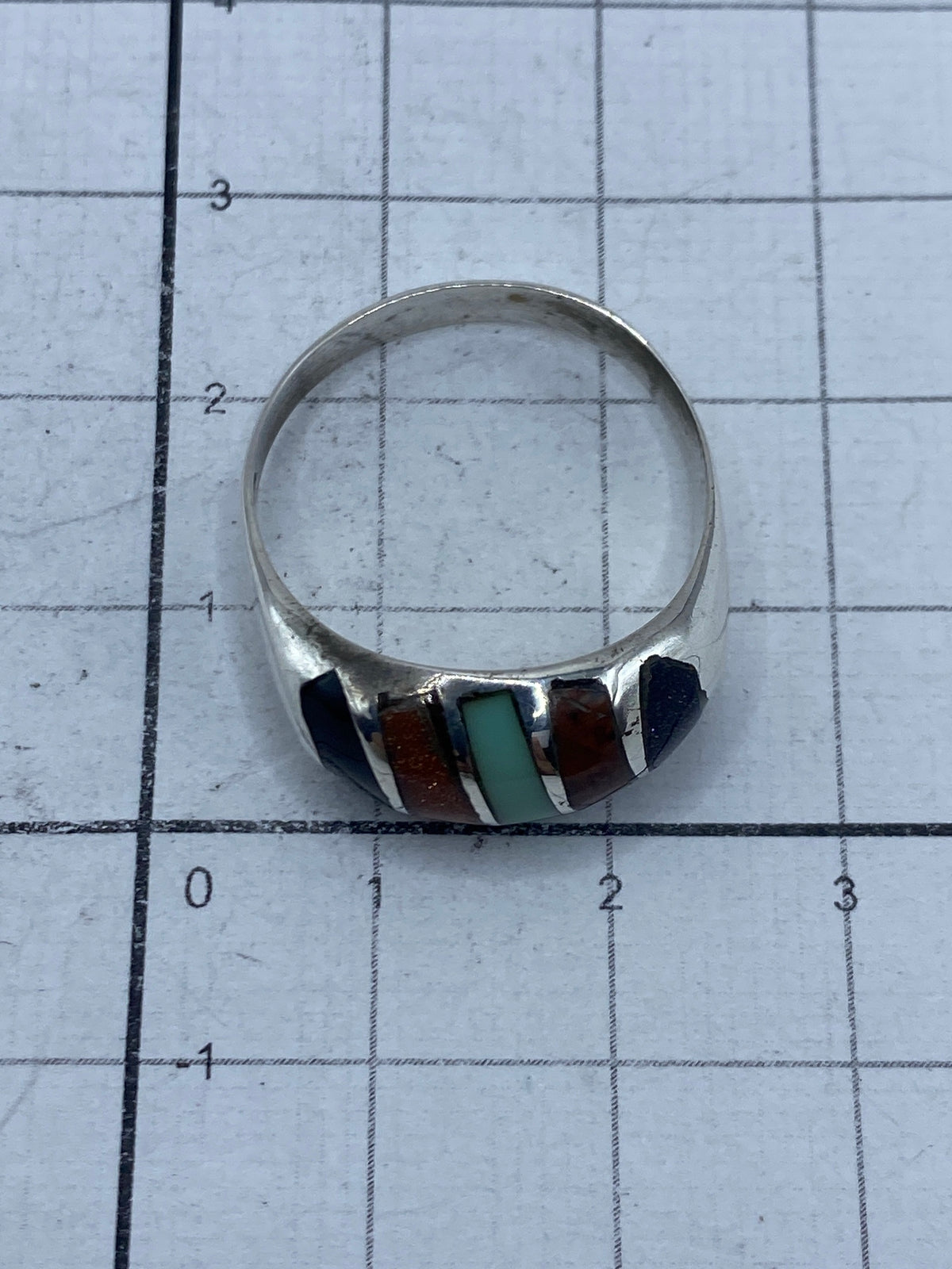 Anillo sobre papel milimetrado con sello de plata 925 visible en el interior