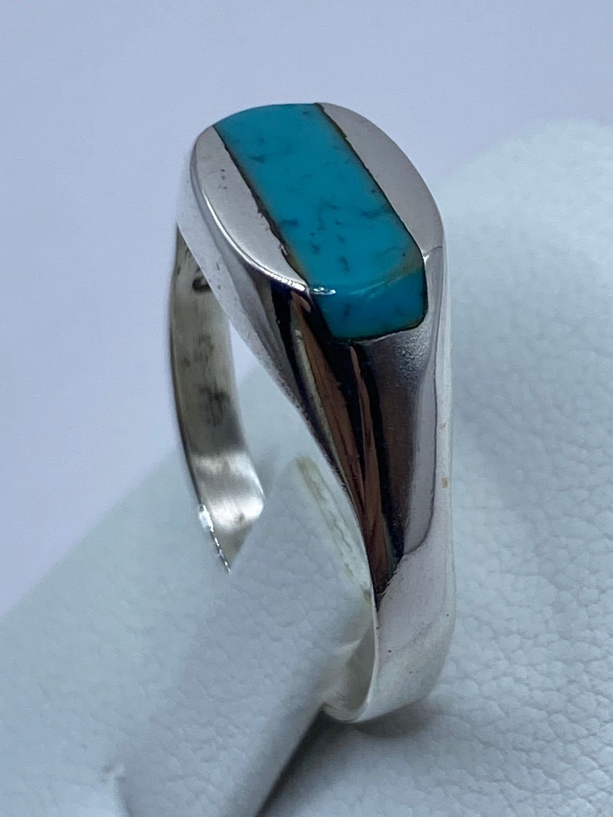 Detalle del anillo en la mano evidenciando el color azul cielo de la turquesa