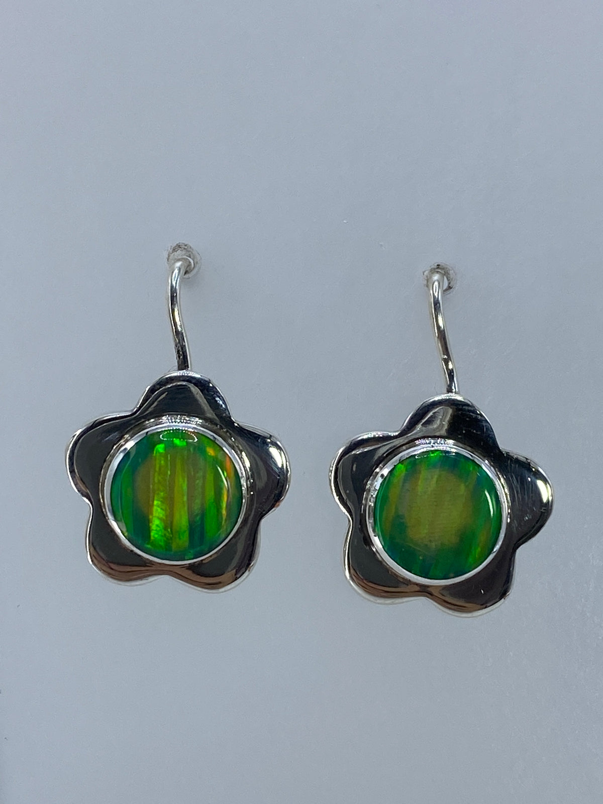 Detalle de la incrustación de ópalo de fuego verde en plata 950, visto de frente