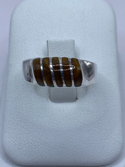 Anillo de plata 925 con Ojo de Tigre café engastado, visto de frente en presentador blanco