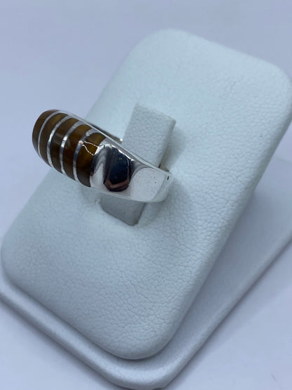 Detalle lateral del anillo mostrando el engaste a mano del Ojo de Tigre y el pulido de la plata