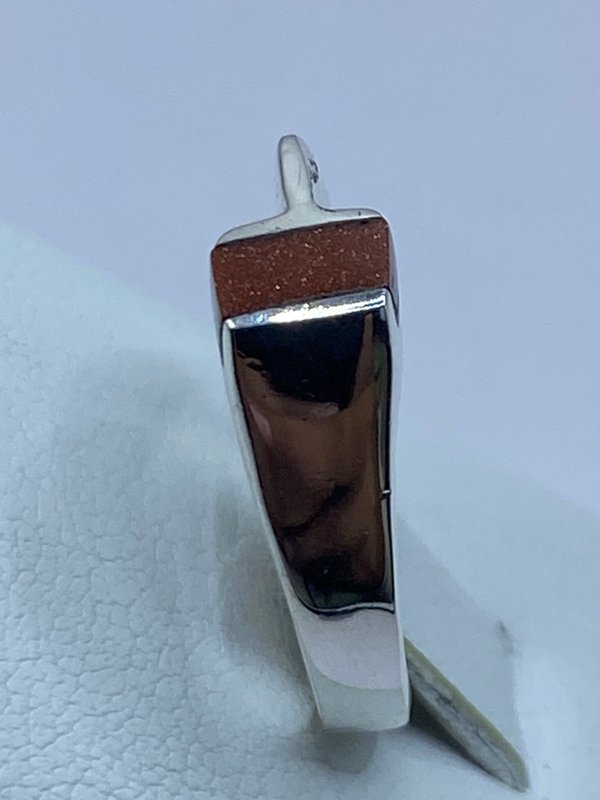Anillo sobre superficie gris mostrando el engaste y el Quinto 925 grabado