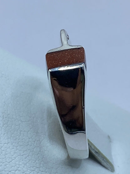 Anillo sobre superficie gris mostrando el engaste y el Quinto 925 grabado
