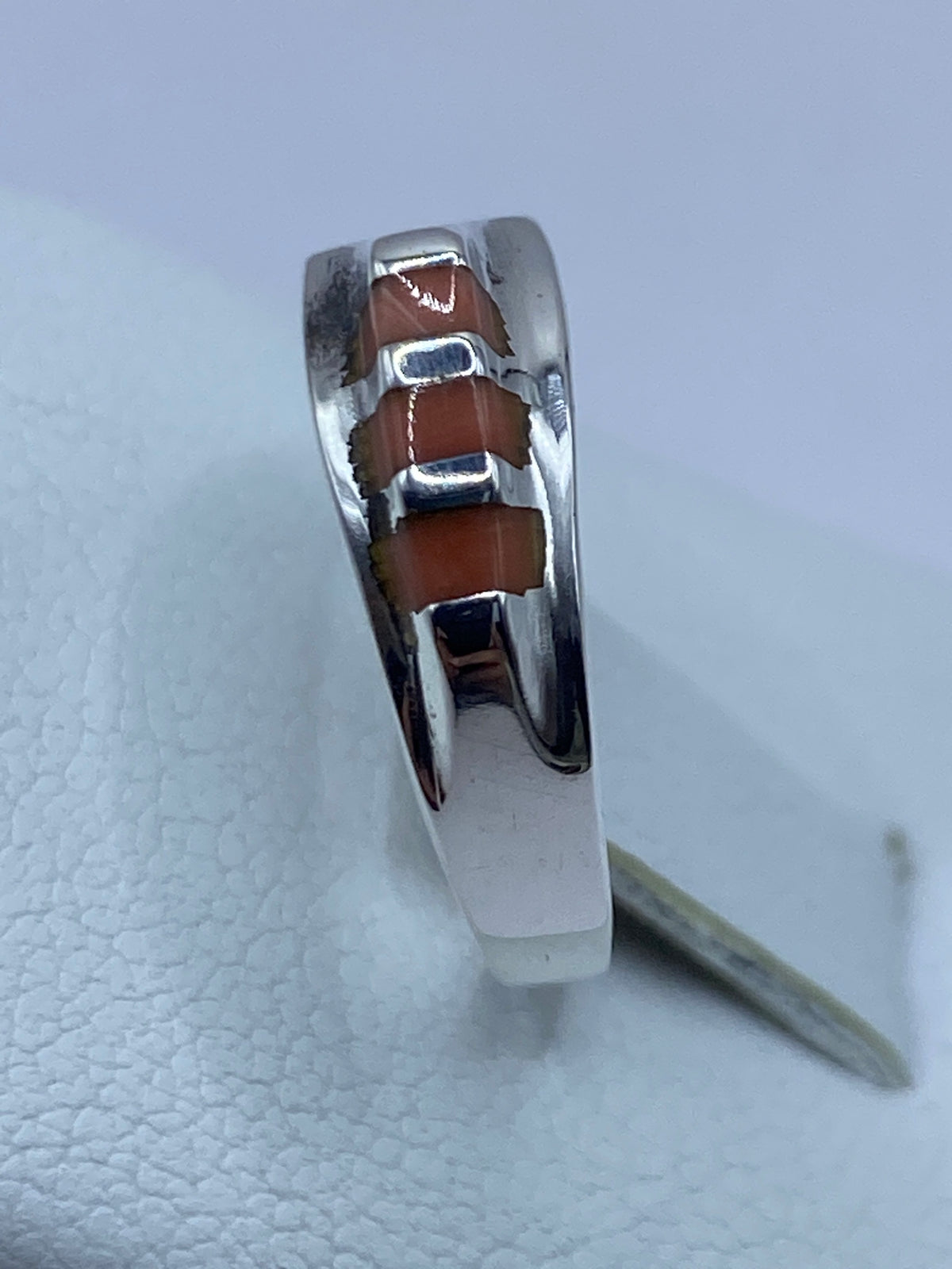 Anillo en la mano de una mujer, luciendo el coral en contraste con la piel