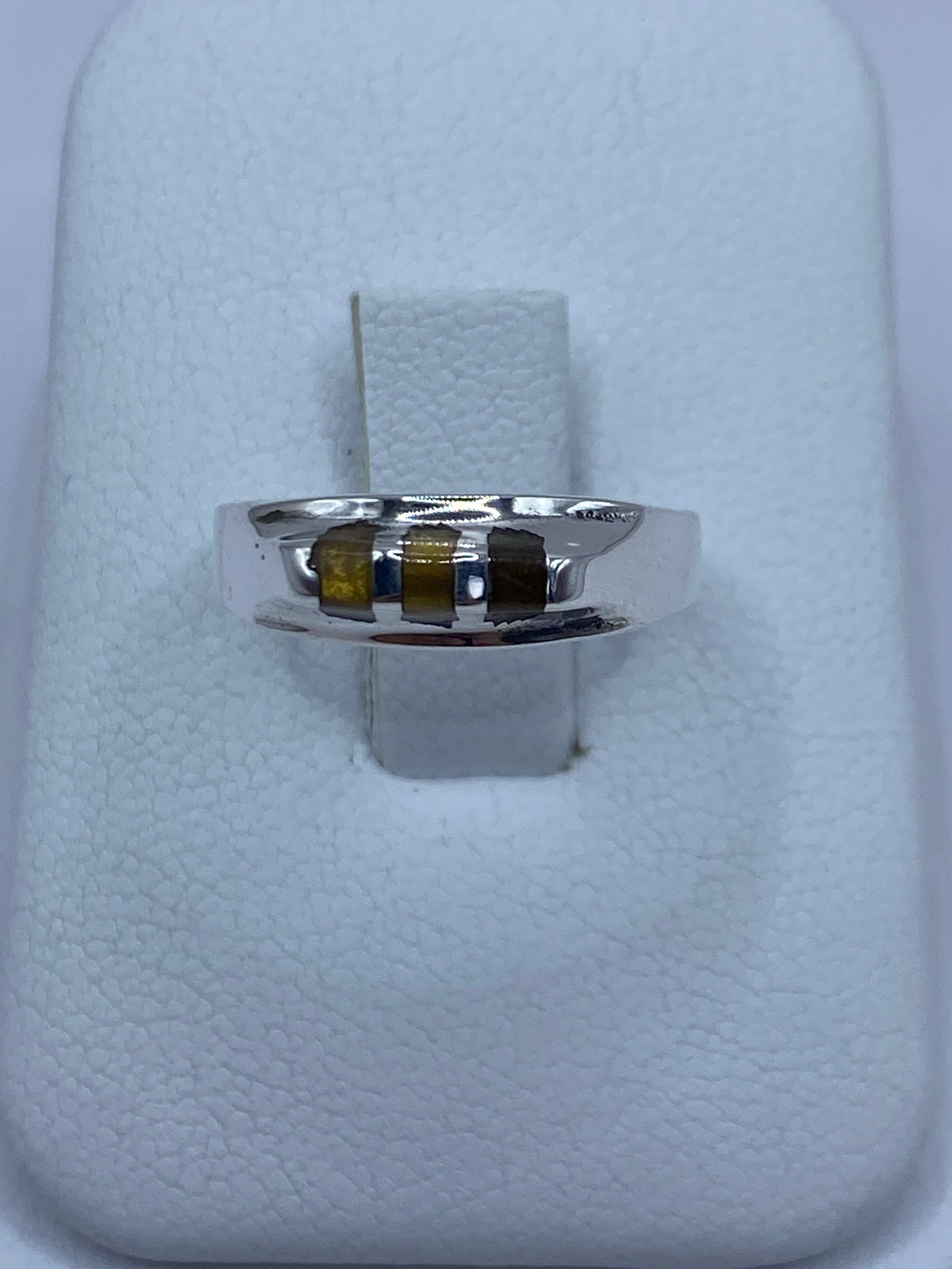 Anillo de plata con piedra ojo de gato café, vista frontal sobre fondo blanco