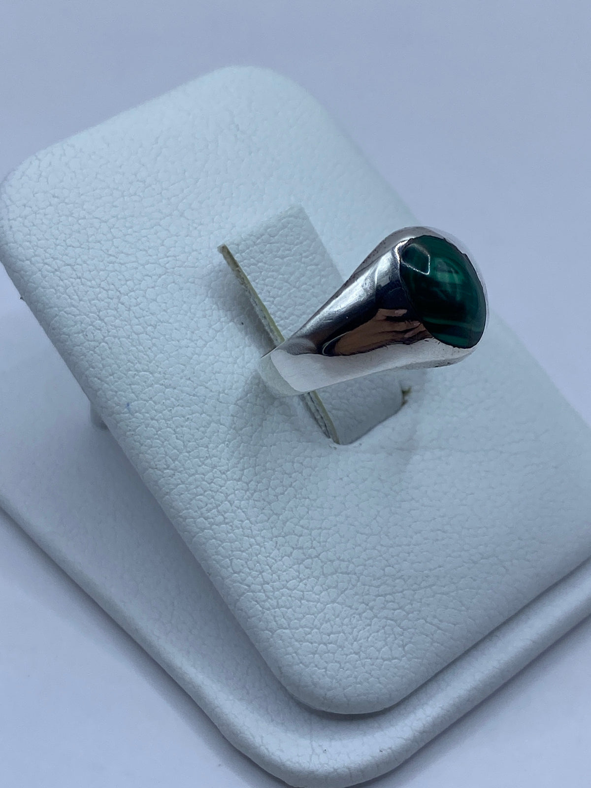 Anillo de plata 925 con malaquita en la mano, detalle del engaste