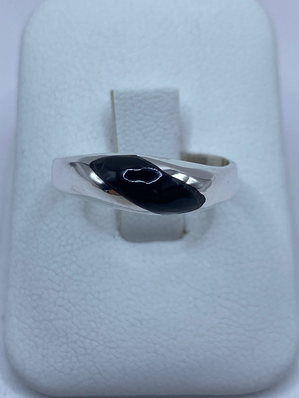 Anillo de plata 925 con ónix negra engastada en la mano de una persona