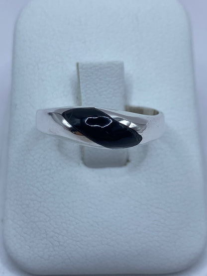 Anillo de plata 925 con ónix negra engastada en la mano de una persona