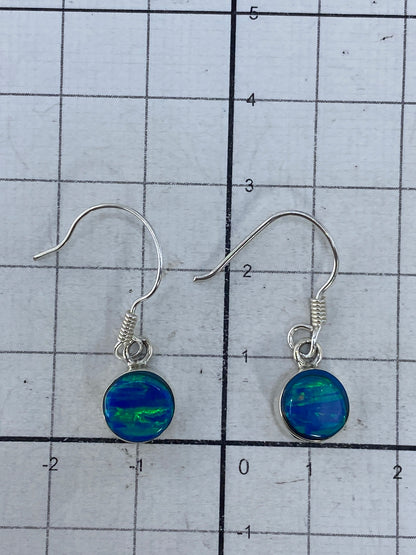Aretes en balanza digital mostrando peso de 1.42 gramos para el par