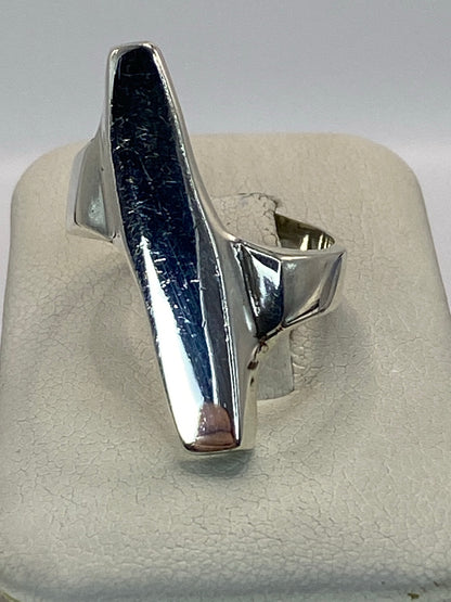 Anillo de plata 925 sólido minimalista en la mano de una mujer, pulido de alto brillo