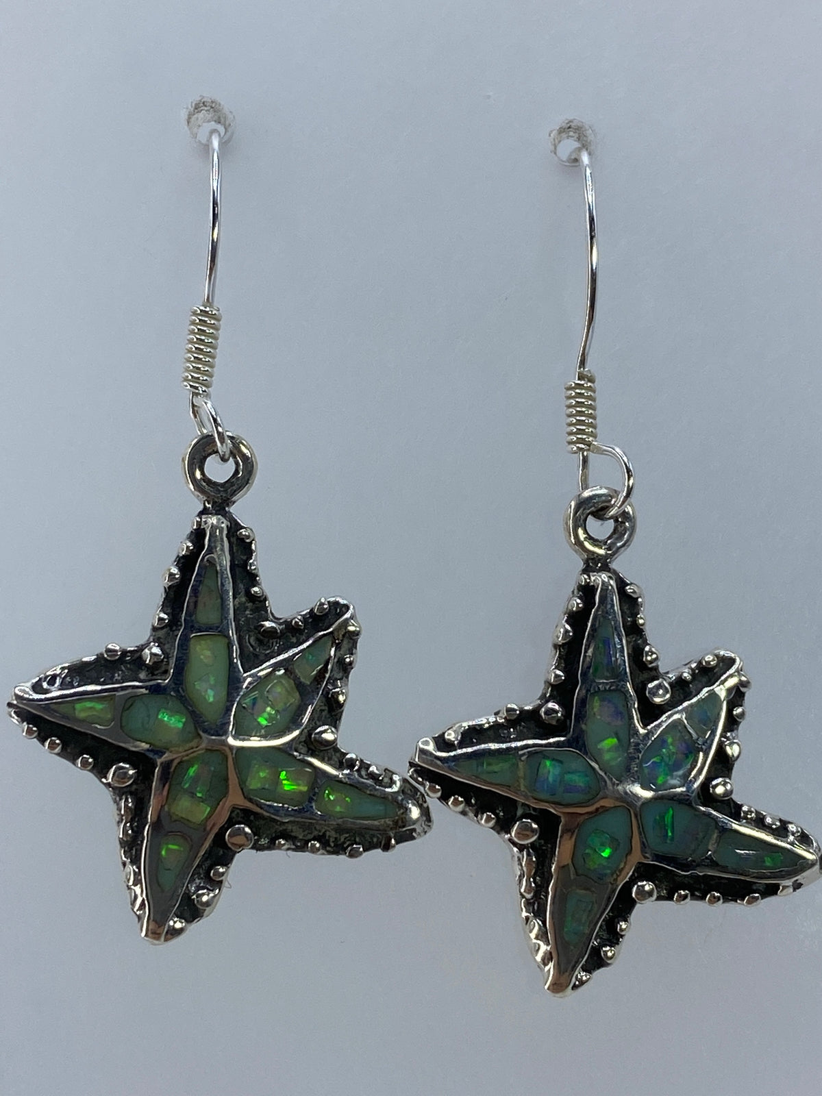 Detalle del ópalo de fuego con tonalidad verde olivo engastado en plata 950