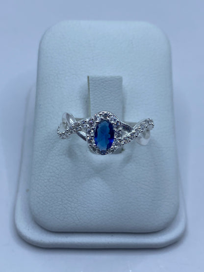 Anillo de plata 925 con circonia azul y micro-circonia blanca en tono brillante sobre soporte blanco