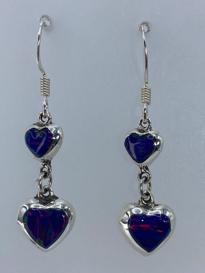 Par de aretes de plata con ópalo de fuego multicolor, vista frontal mostrando bandas de rojo y naranja