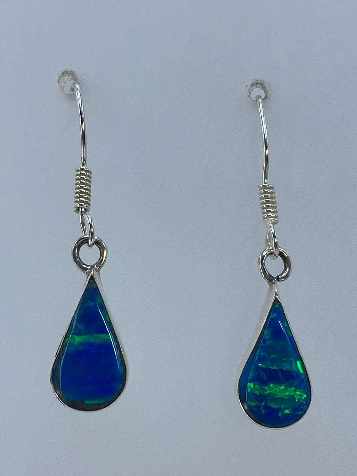 Aretes de plata 950 con opalo de fuego verde olivo — par completo sobre fondo gris