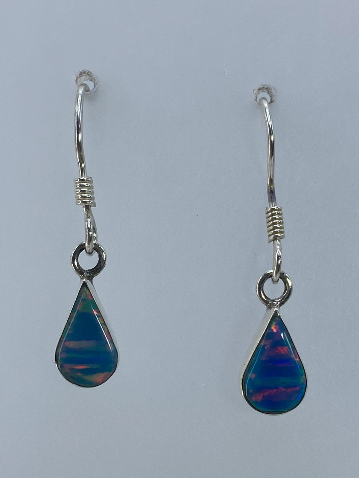 Aretes colgando, destacando el largo de 3 cm y el engaste delicado de la piedra en plata 950
