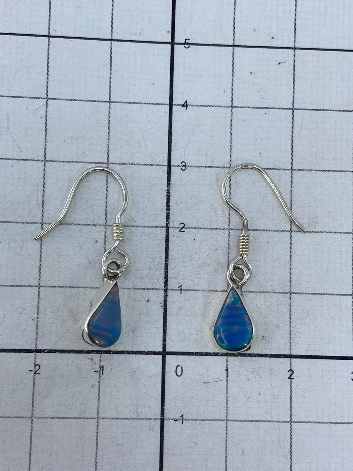 Aretes sobre fondo blanco con marca del Quinto 950 visible en el gancho de plata