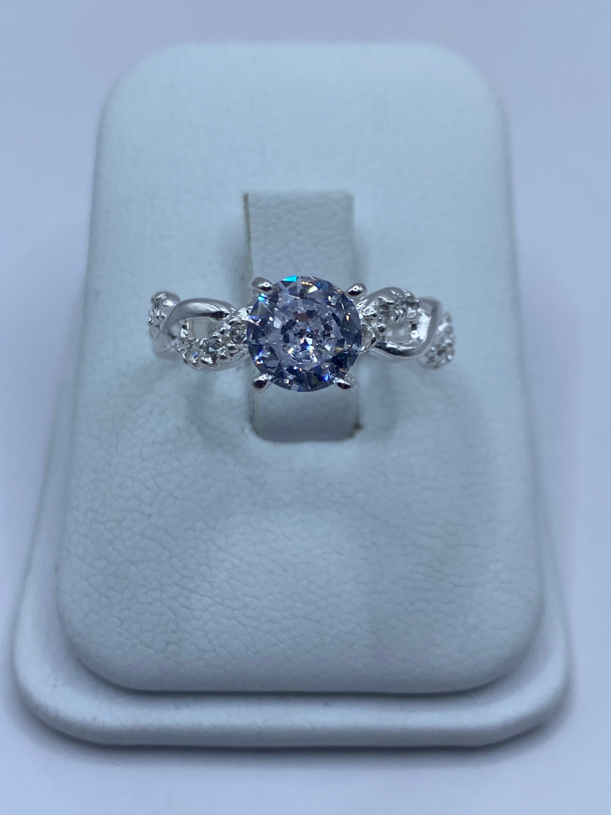 Anillo de plata solitario con circonia blanca brillante en dedo de mujer