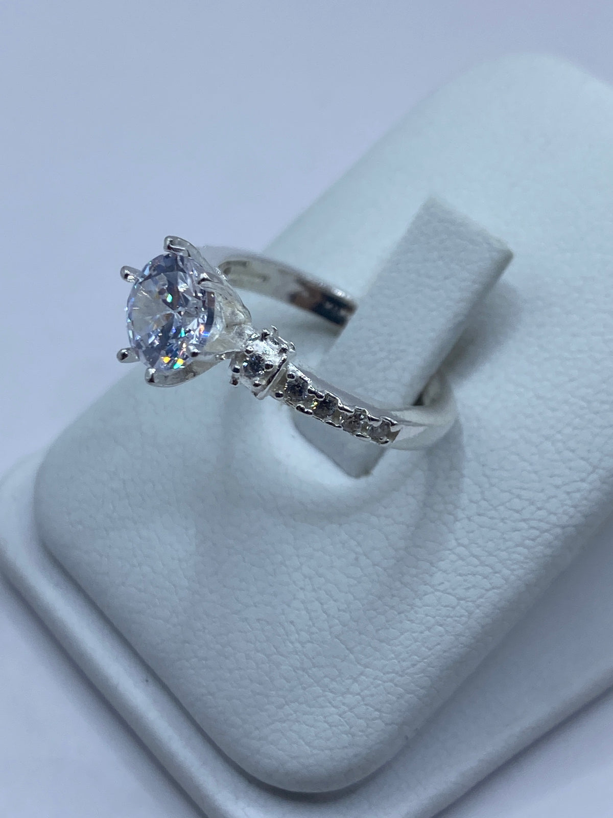 Anillo solitario en la mano de una mujer, mostrando la claridad de la piedra